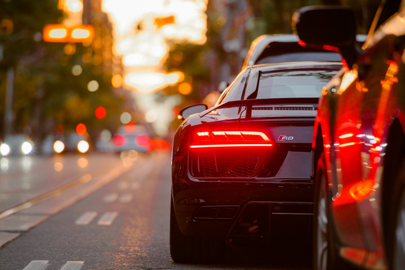 Sports car tail lights glowing in evening city traffic