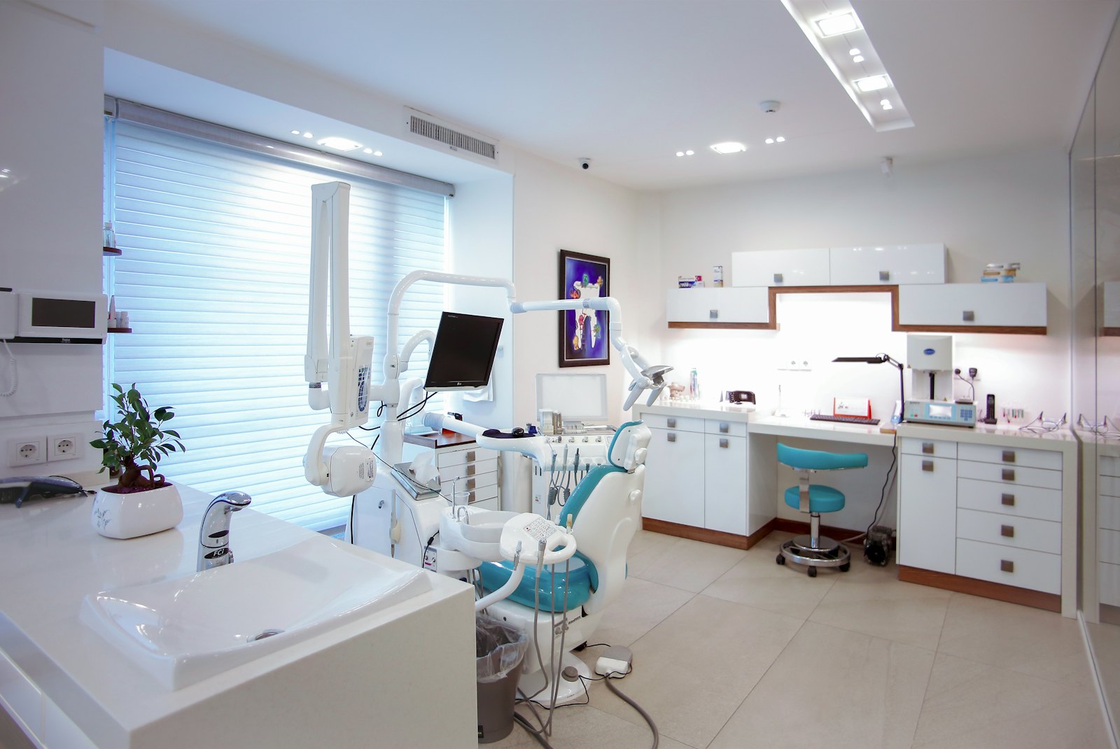 Bright, modern treatment room at Pearl Dental Studio with a turquoise dental chair