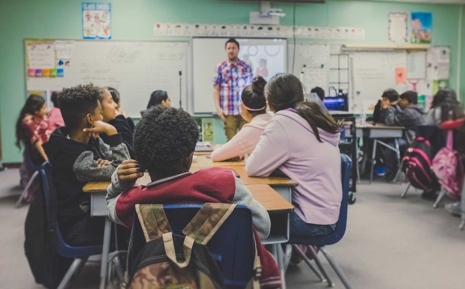 Teacher leading a lively lesson in a classroom full of young students