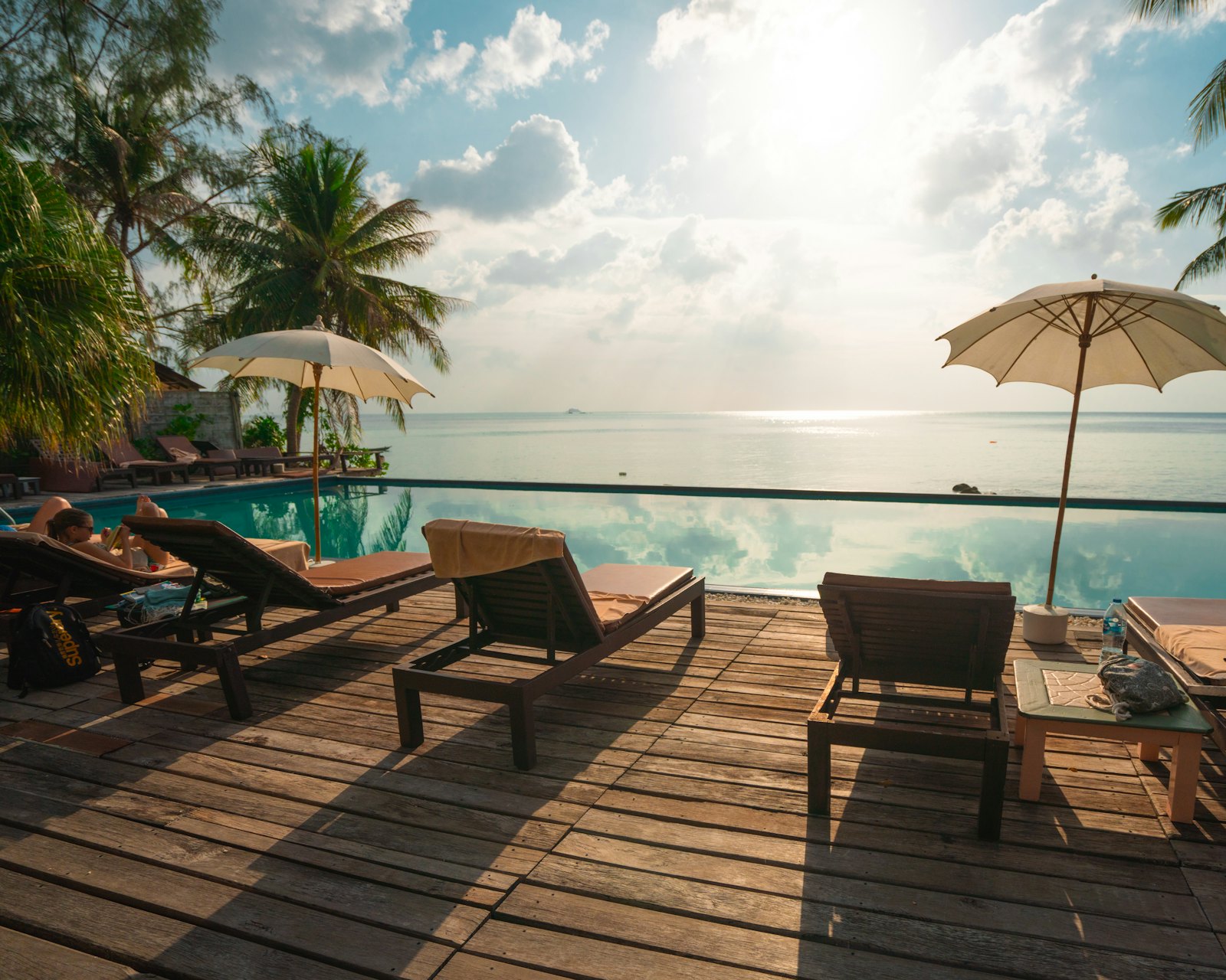 Private sun terrace of the Terrace Suite with loungers and parasols overlooking the water