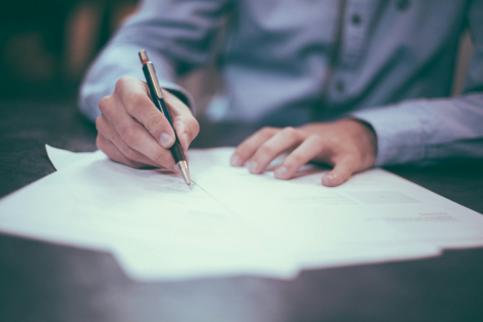 Solicitor reviewing and signing legal documents at a desk
