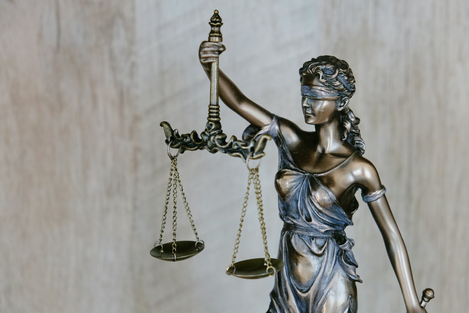 Bronze statue of Lady Justice holding balanced scales