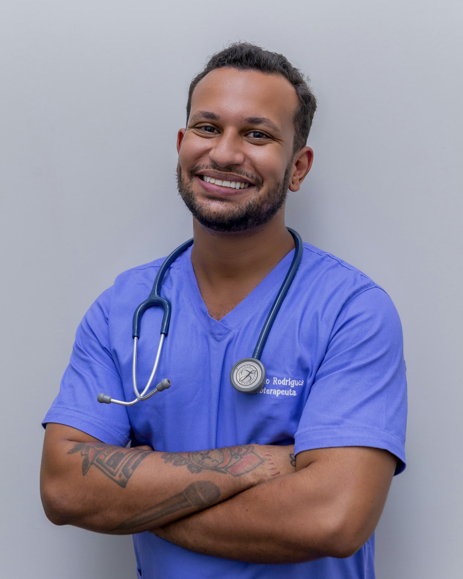 Portrait of a smiling male doctor in blue scrubs with a stethoscope