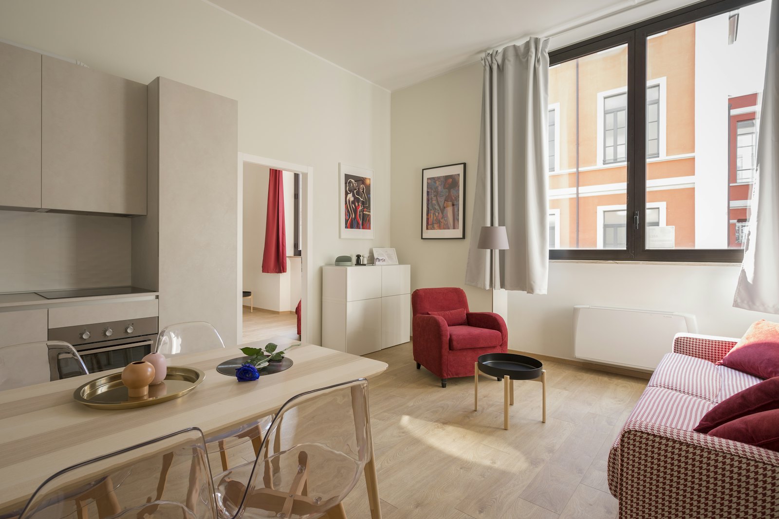 Bright city apartment with open kitchen, dining table, and sunlit living corner