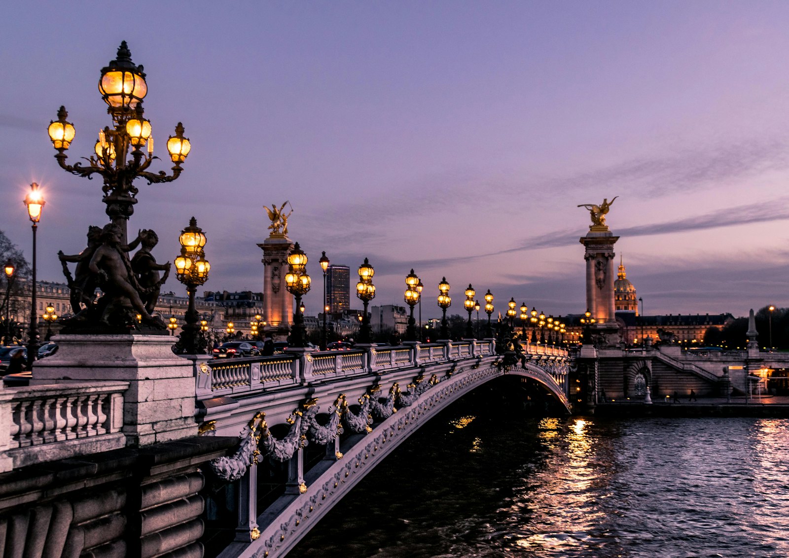 Pont Alexandre III bridge in Paris lit by ornate lamps at dusk
